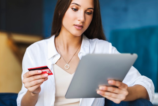 Female using bank card to pay for goods purchased online.