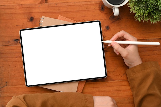 Female using or designing her graphic art work on digital tablet screen over her wooden office desk