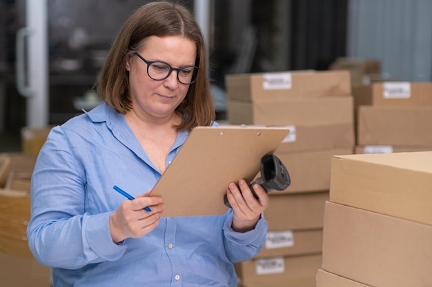 Female using a laptop to manage small business and package products delivery or express shipping