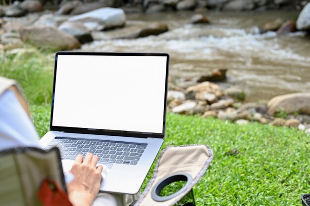 Photo female using notebook laptop while taking a vacation at the natural campground