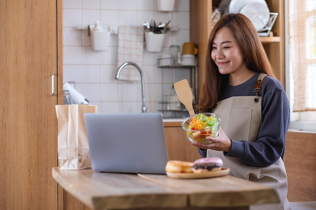 A female video blogger cooking food in the kitchen and filming for online learning cooking class concept