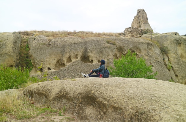 Female Visitor Sitting on the Rock of Ancient Uplistsikhe Rock Cave City Georgia