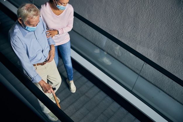 Female volunteer helping for man with a cane