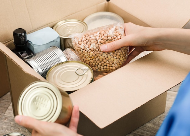 A female volunteer puts groceries in a cardboard box humanitarian aid to refugees and the poor