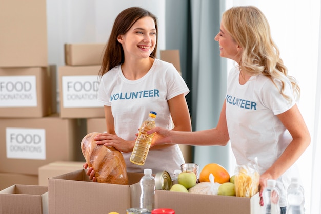 Female volunteers preparing food provisions for donations