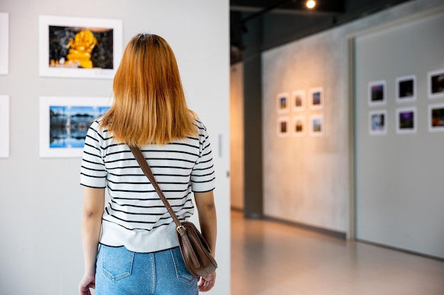 Female watch at photo frame to leaning against at exhibit museum