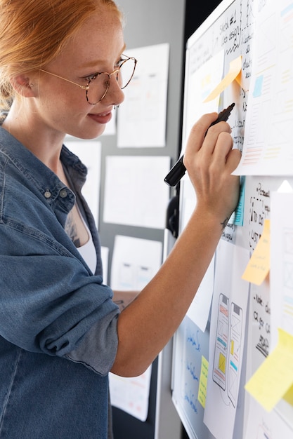 Female web designer with papers and notes in the office