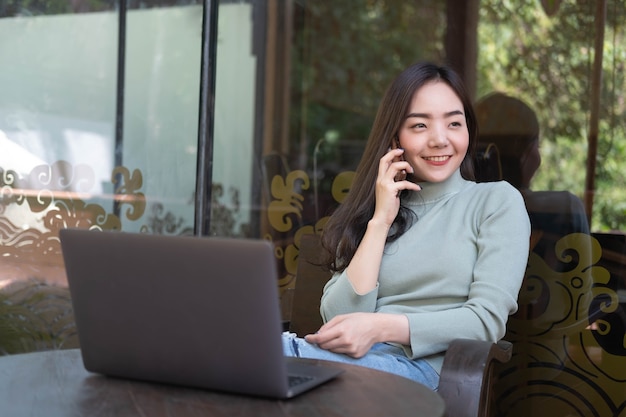 Female with cute smile having talking with mobile phone while rest in cafe Relaxing time