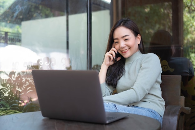 Female with cute smile having talking with mobile phone while rest in cafe Relaxing time