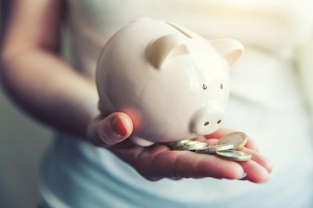 Female woman hands holding pink piggy bank and euro coins Saving investment budget business wealth retirement financial money banking concept