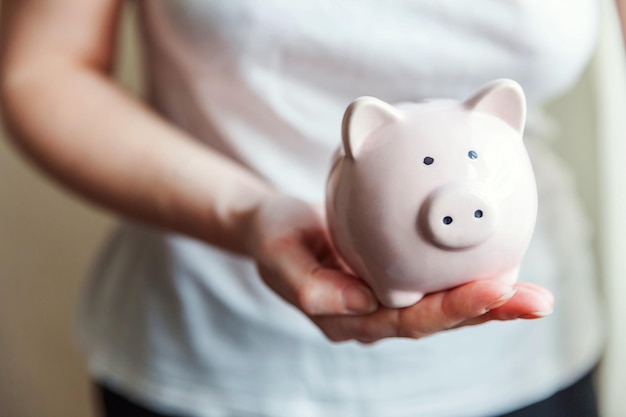 Female woman hands holding pink piggy bank Saving investment budget business wealth retirement financial money banking concept