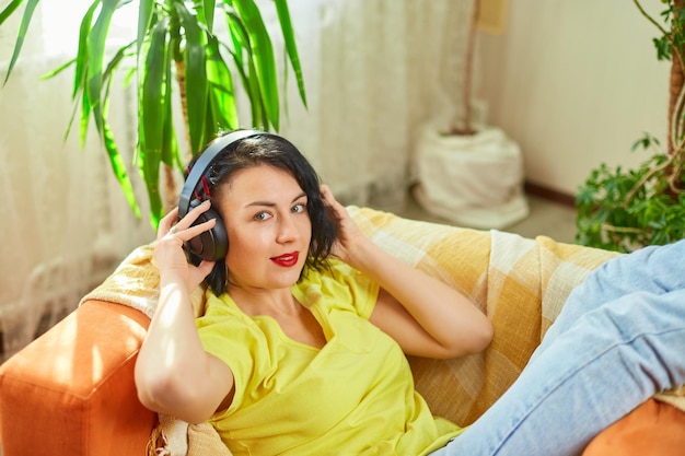 Female woman in headphones with eyes closed listening to music podcast