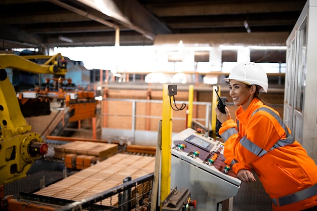 Female worker controlling parts assembling in factory Industrial machines working in background