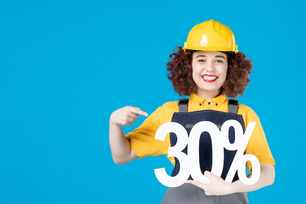 Female worker in yellow uniform with sign on blue