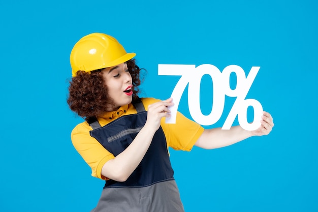 Female worker in yellow uniform with sign on blue