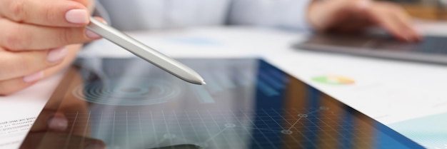 Female working on tablet with diagrams and charts on device screen