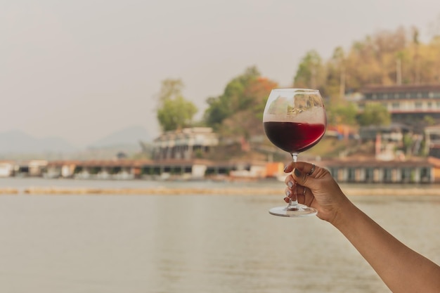 Feman hand holding glass of red wine