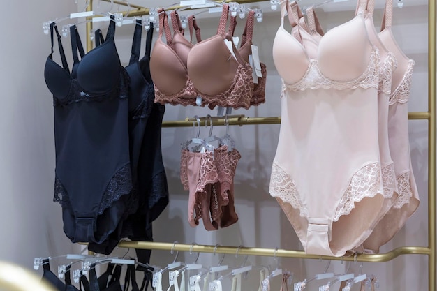 Feminine bodysuits on hangers in a lingerie store Elegance and sexy