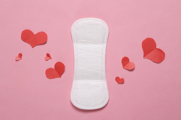 Feminine hygiene concept Menstrual woman pads for hygiene protection in critical days with hearts on pink pastel background