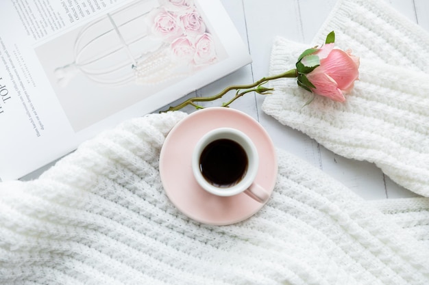 Feminine modern home office desk with pastel pink notebook glasses coffee cup wildflowers