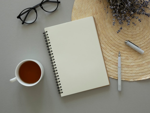 Feminine table Flat lay mockup. Dry flowers, opened notebook with copy space and cup of tea