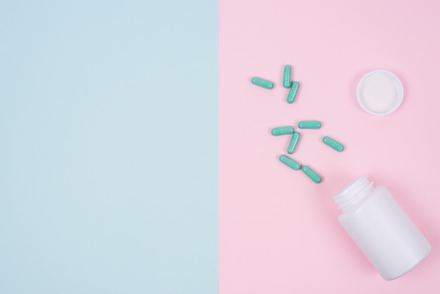 Feminine woman gynecology. Top above high angle flatlay flat lay overhead close up view photo pattern of small opened unpacked unwrapped container with pills isolated on pink blue background