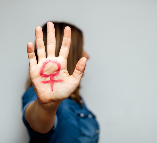 Feminism symbol painted on the palm of a woman39s hand