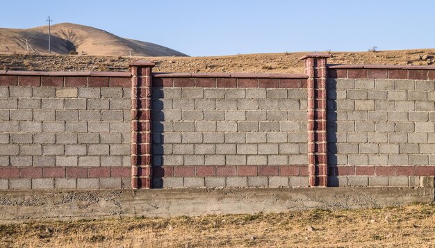 Fence made of slag bricks in a mountainous area