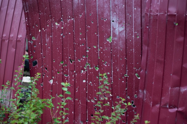 Fence near the house with bullet holes and charapnels after gunshots and fighting during the invasio