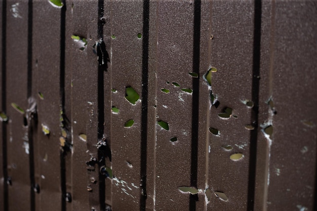 Fence near the house with bullet holes and charapnels after gunshots and fighting during the invasio