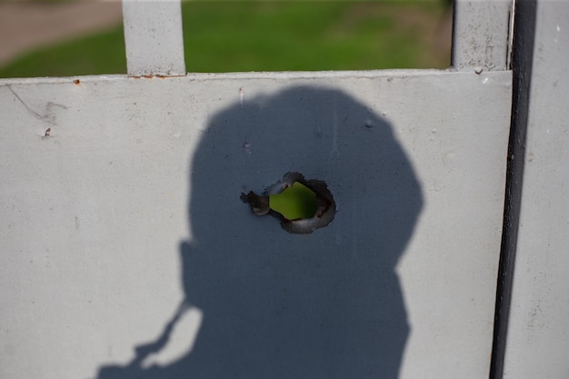 Fence near the house with bullet holes and charapnels after gunshots and fighting during the invasio