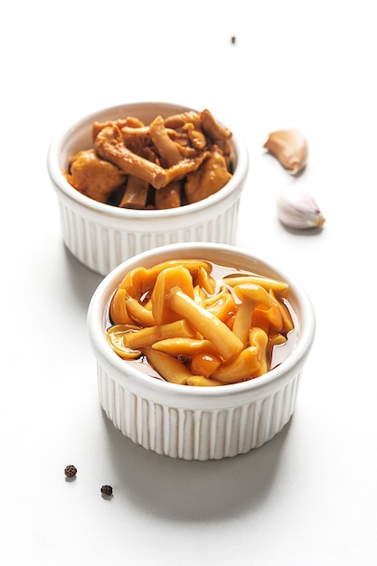 Fermented food. Canned mushrooms in bowls on a white background.