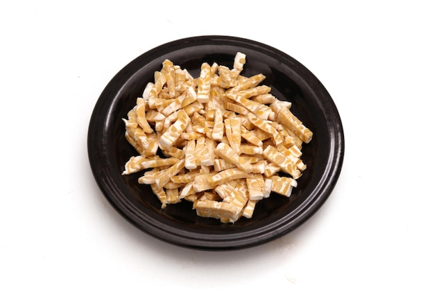 fermented soybeans that have been cut into small pieces on a black plate