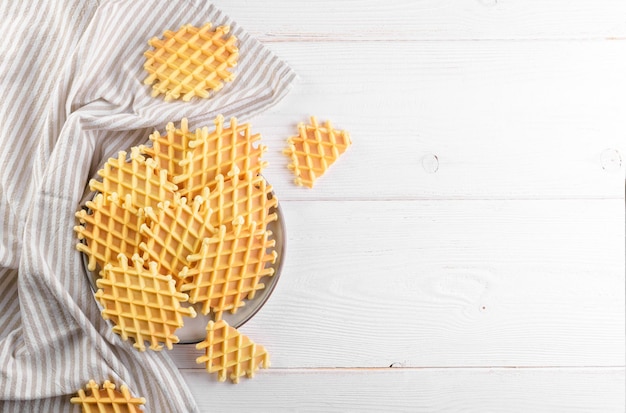 Ferratelle or pizzelle a traditional dessert or cookies from Abruzzo on a plate on a white wooden background top view