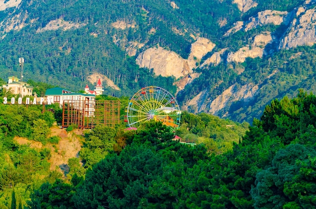 Photo a ferris wheel is in the distance in front of a mountain.