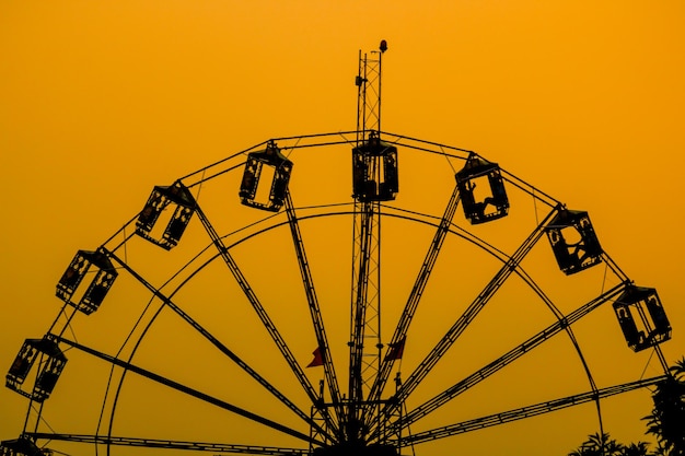 A ferris wheel with a yellow sky in the background