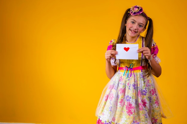 Festa Junina in Brazil young girl holding a love letter at the brazilian june festival wearing costume