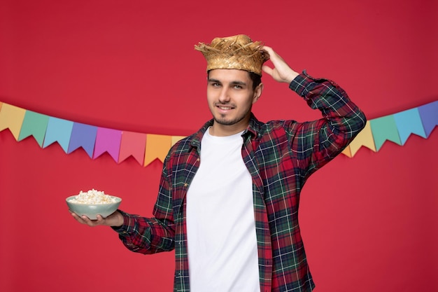 Festa junina happy cute guy wearing straw hat celebrating brazilian festival touching hat