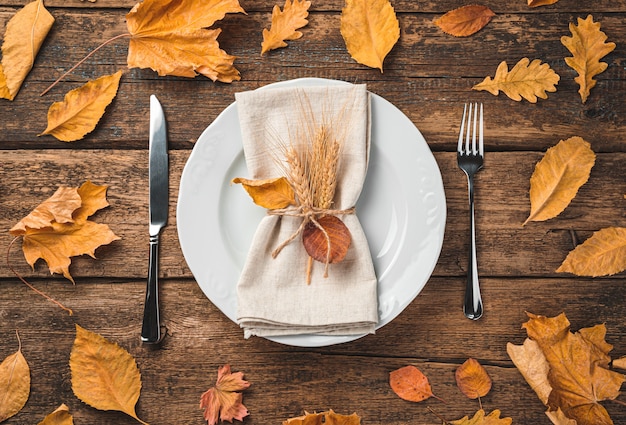 Festive autumn culinary background with a plate serving napkin and cutlery