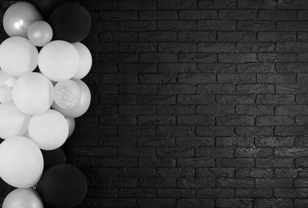 festive black brick background with white balloons