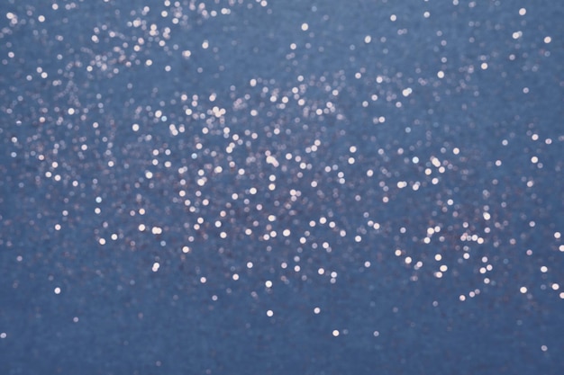 Festive Blue background of silver glitter lights. Winter blurred abstraction