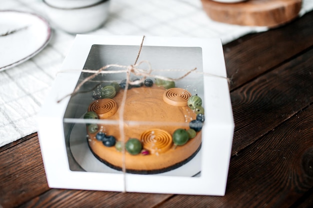 Festive brown eco cake with berries and fruits in a gift box