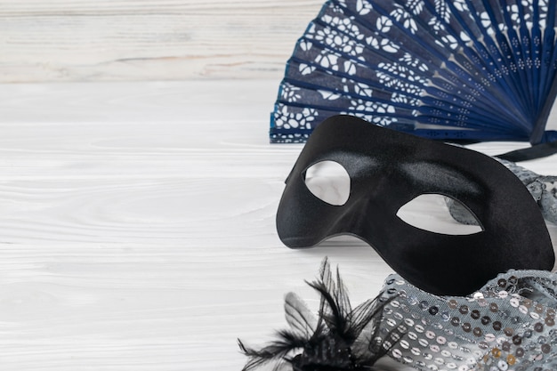 Festive carnival accessories, satin black mask, elegant vintage fan and jewelry