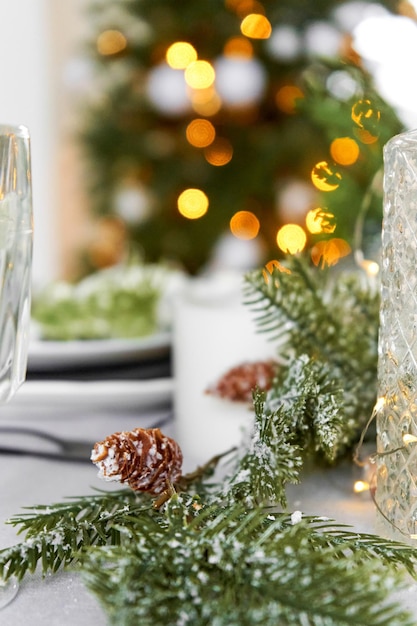 Festive Christmas decorations a pine branch with cones decorate the dinner table