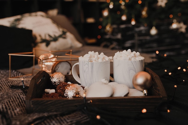 Festive Christmas food on a wooden tray Coffee with marshmallows and gingerbread