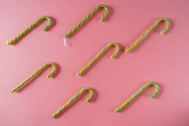 Festive Christmas ornaments and decorations with candy canes on pink paper backgroundtop view