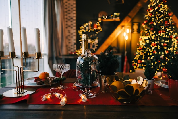 Festive Christmas table in the kitchen with a big Christmas tree and decorations.