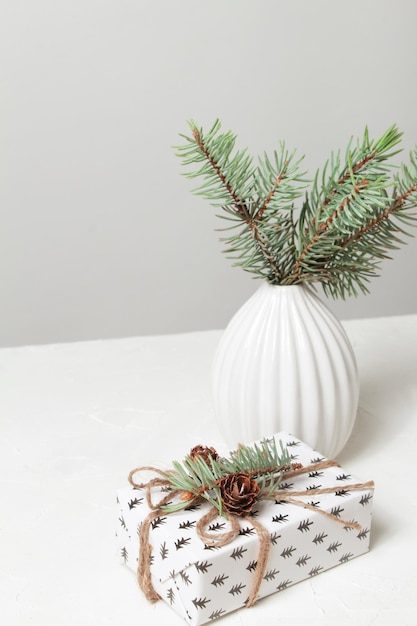 Festive christmas table vase with pine branches and gift box