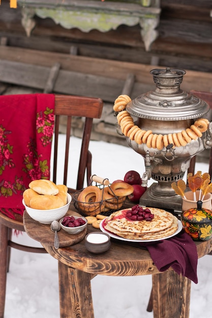 Festive decor for Maslenitsa on the table pancakes bagels a samovar  Shrovetide concept