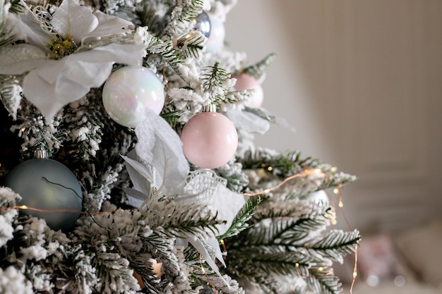 Festive decorChristmas decorations on the snowcovered branches of an artificial Christmas treeNew Year's background winter holidays home interior